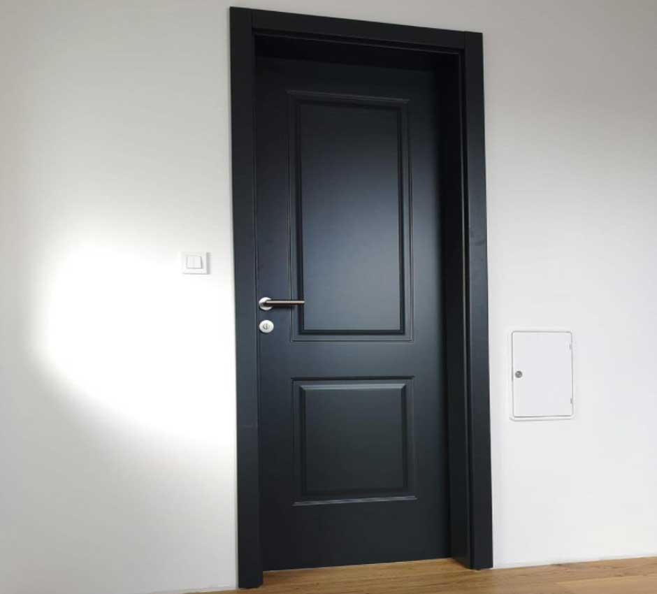 Ahşap kapı boyası renkleri için kullanılan görselde, siyah renkli estetik bir panel kapı var.