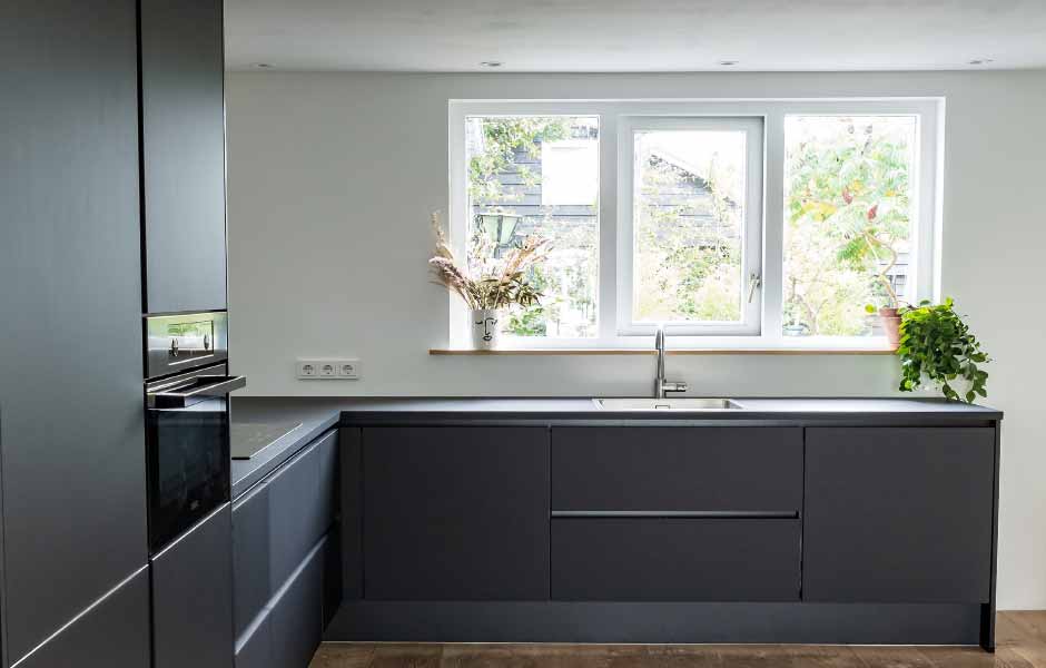 İç cephe renklerin anlamları için kullanılan görselde, saf beyaz renge boyanmış siyah dolaplı modern bir mutfak var.