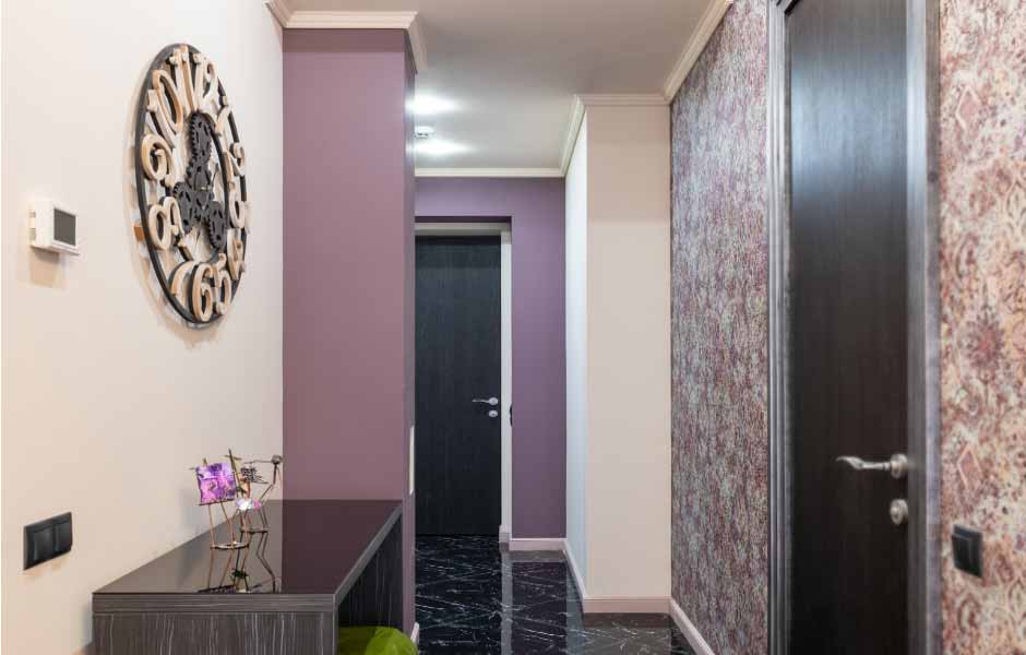 Görselde, bir eve ait mor renge boyalı modern bir koridor girişi var.
