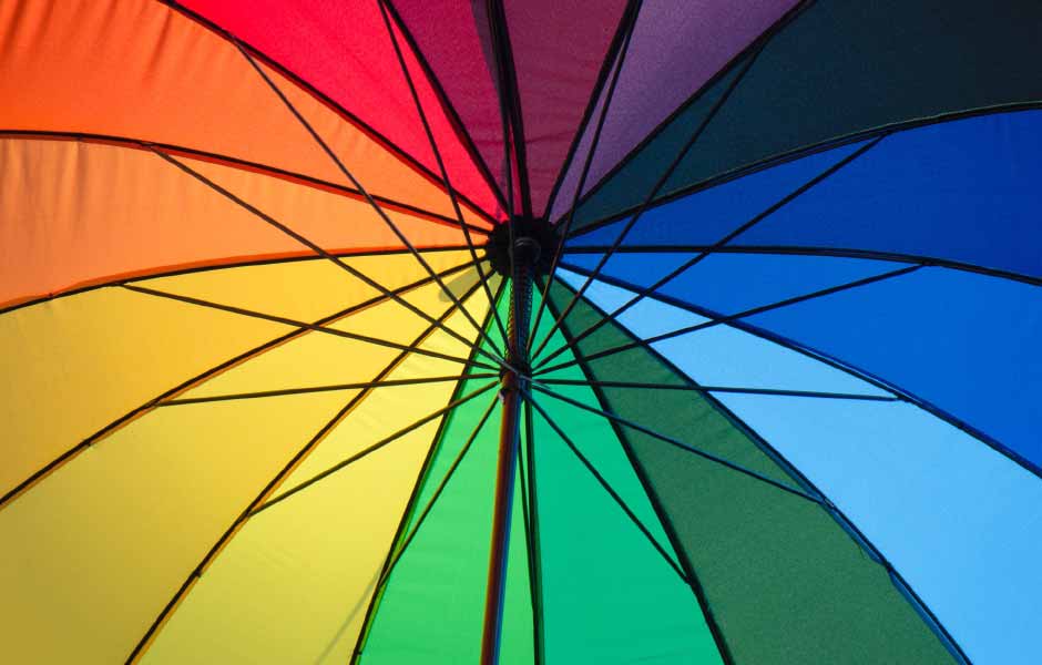 Görselde, sarı, kırmızı, yeşil ve mavi renk şemalarına sahip güzel bir şemsiye var.