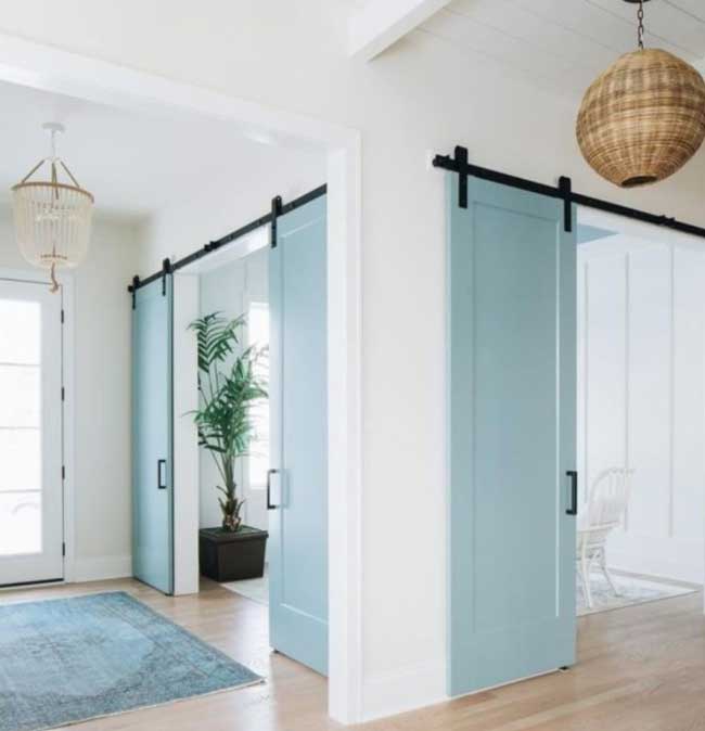 Ahşap kapı boyası renkleri için kullanılan görselde, salona açılan açık mavi renginde bir kapı var.