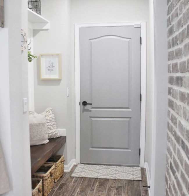 Görselde, gri renkli ahşap bir banyo kapısı var.