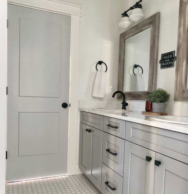 Görseldeki banyoda, gri ahşap boyası ile boyanmış bir panel kapı var.