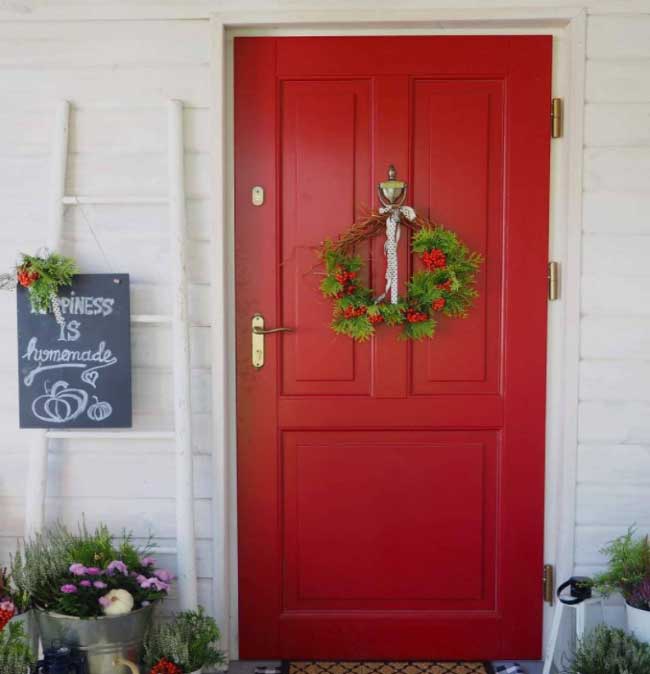 Görselde, kırmızı renkli ahşap bir ön giriş kapısı var.