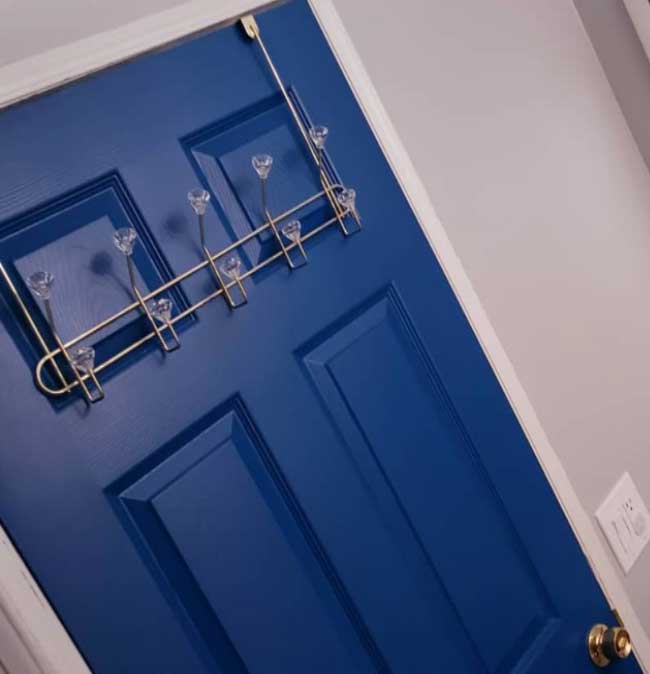 Görselde, mutfağa açılan lacivert renkli modern bir ahşap kapı var.