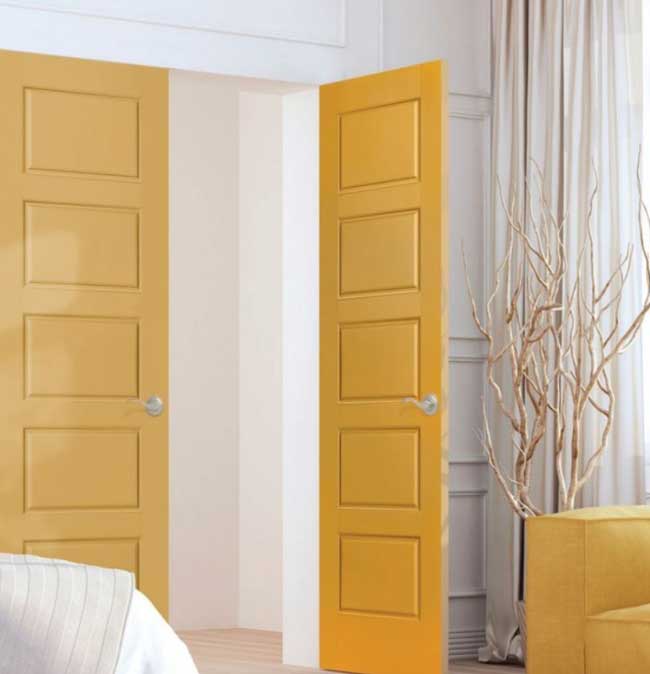 Görselde, hardal sarısı renginde modern bir ahşap kapı var.