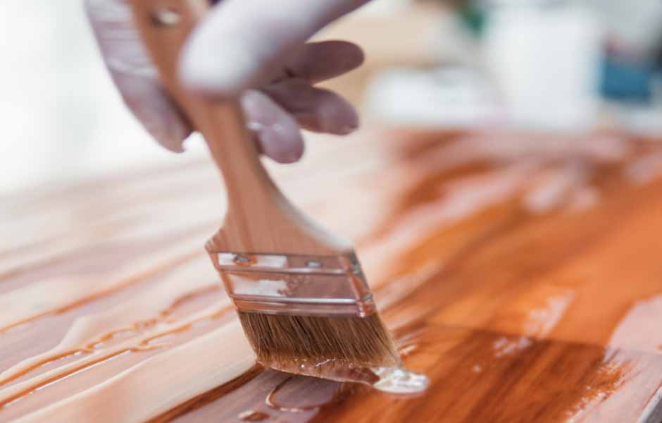 Görselde, İstanbul boyacı ustası çelik kapıyı fırçayla ahşap renge boyuyor.