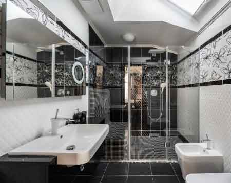 Fayans modelleri fiyatları kategorisi için kullanılan görselde, zemini siyah ve duvarları beyaz, dokulu karolarla döşenmiş modern bir banyo var.