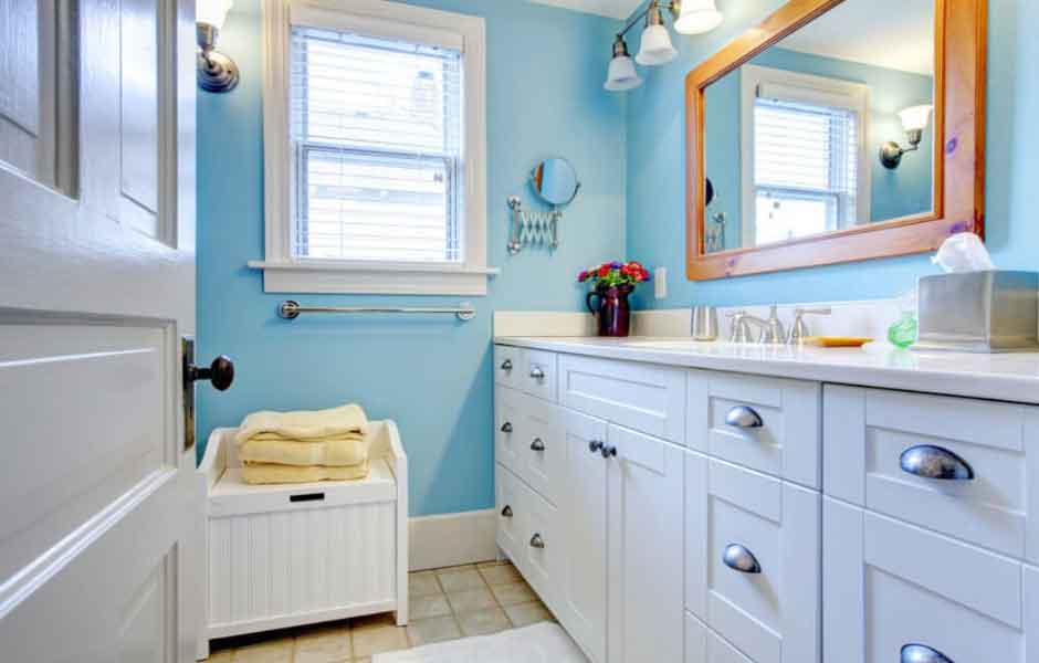 Görselde, açık mavi duvarları olan ferah bir banyo var.