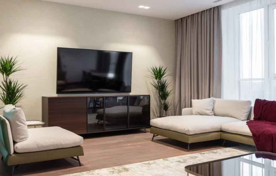 Görselde, led aydınlatma sistemine ve bej renkli duvarlara sahip aydınlık bir oda var.