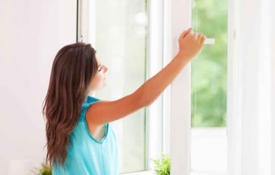 Görselde, kadın rutubeti önlemek için pencereyi açıp doğalgazlı evi havalanrıyor.