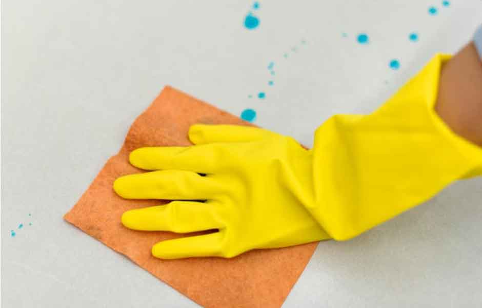 Görselde, ev sahibi laminant parkeye yeni damlamış mavi lekeleri yumuşak bir bezle silerek anında müdahale ediyor.