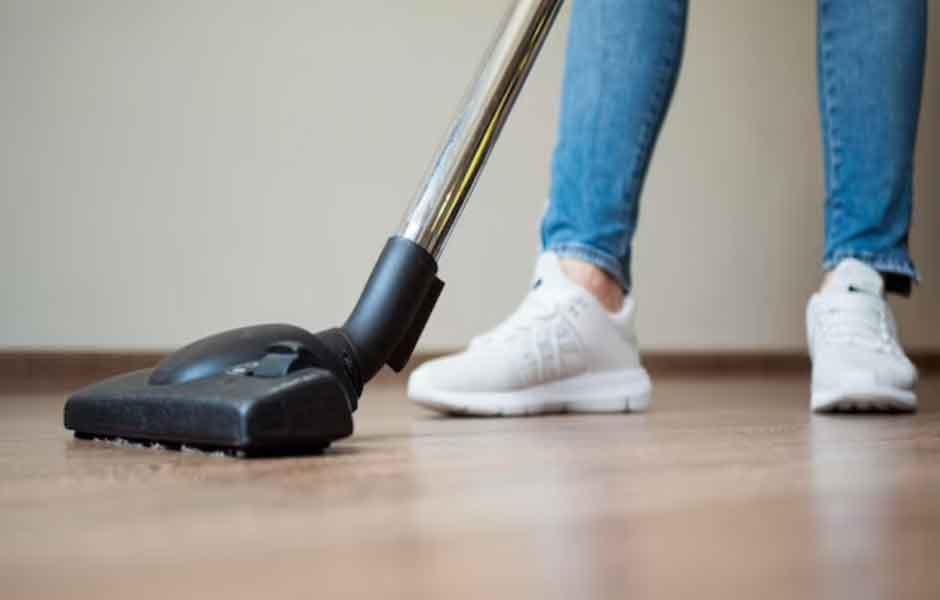 Laminant parke neyle nasıl temizlenir sorusu çin kullanılan görselde, ev sahibi elektrikli süpürge ile parkenin tozunun alıyor.