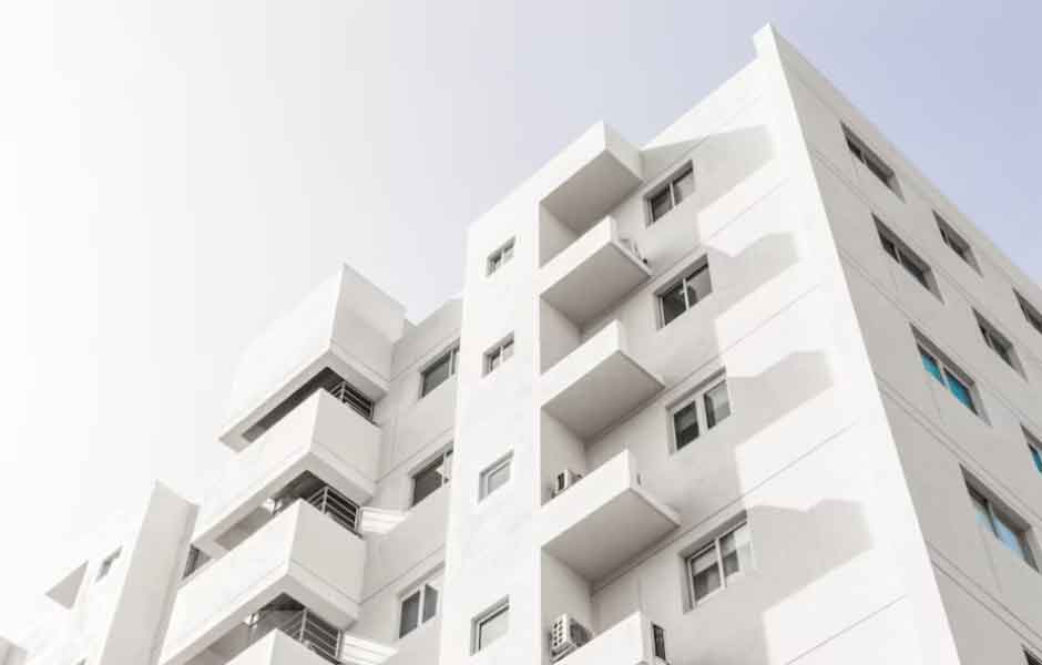 Görselde, su bazlı boyayla boyanacak 5 katlı beyaz bir apartman var.