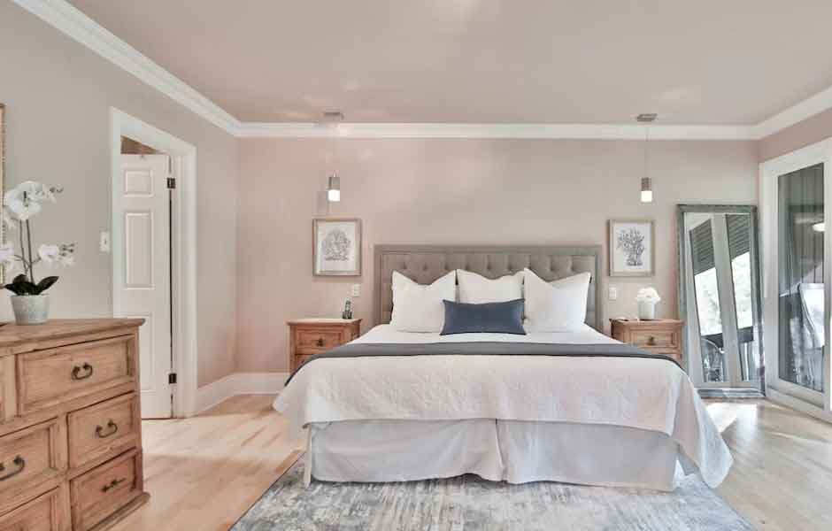 Görselde, bej rengi duvarlara sahip huzur dolu bir yatak odası var.