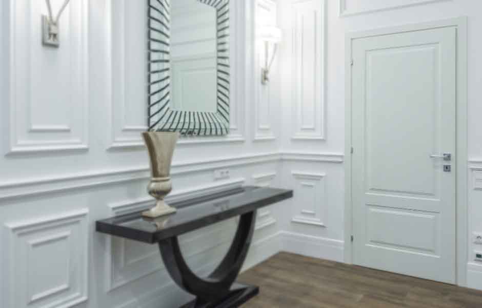 Görselde, mat beyaz renge boyanmış ahşap bir panel kapı var.