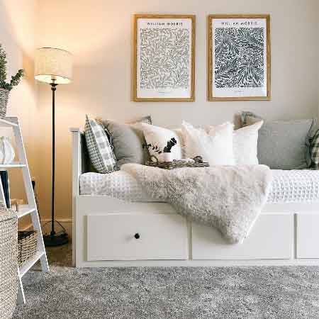 Küçük Oda Dekorasyonu Püf Noktaları. Küçük oda dekorasyonu için kullanılan görselde, içerisinde çekmeceli bir kanepe ve gri duvarlarında çerçeveler olan sade bir oda var.