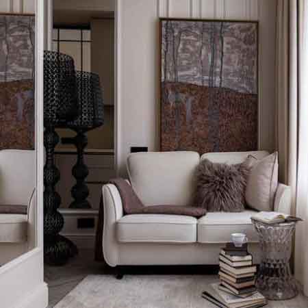 Küçük Oda Dekorasyonu Püf Noktaları. Görselde, içerisinde ikili küçük kanepe ve gri duvarında büyük bir tablo olan dar bir oda var.