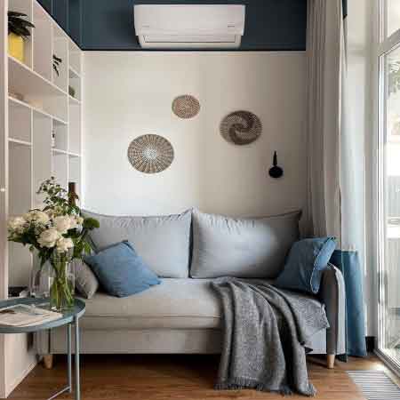 Küçük Oda Dekorasyonu Püf Noktaları. Küçük oda dekorasyonu için kullanılan görselde, beyaz ve mavi duvarlara sahip kompakt bir oturma odası var.