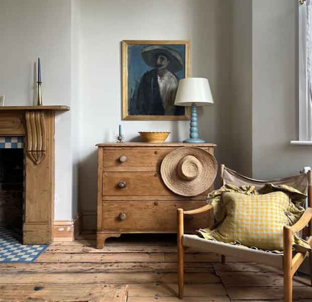 Görselde, eski ahşap dolap, sandalye ve çerçevenin olduğu vintage tarzı bir ev dekorasyonu var.