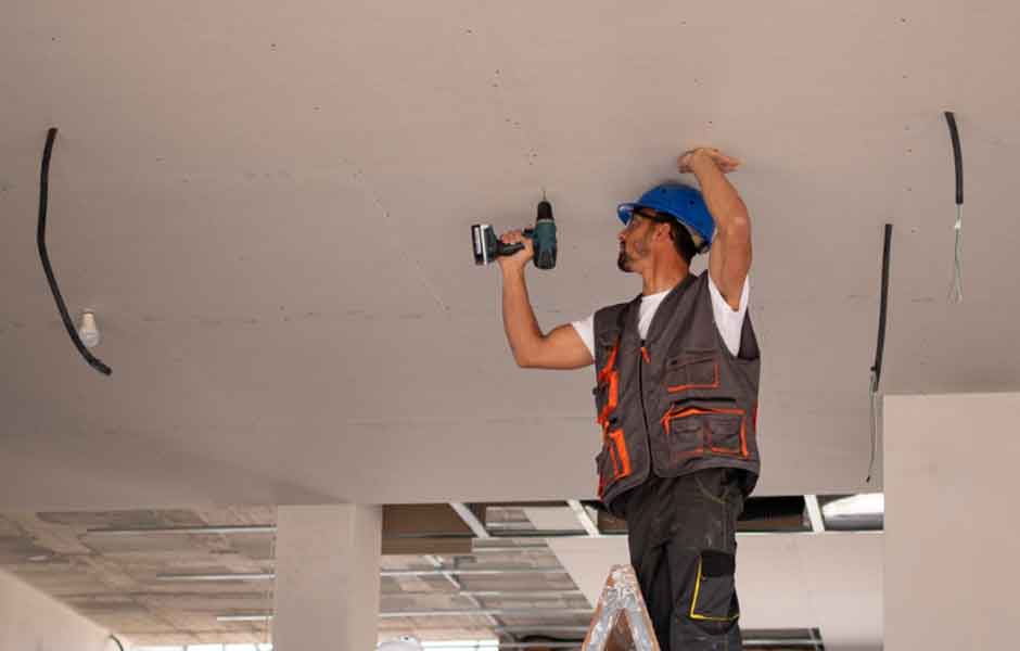 Görselde, alçıpan asma tavan montajı yapan yerel bir boyacı ustası var.