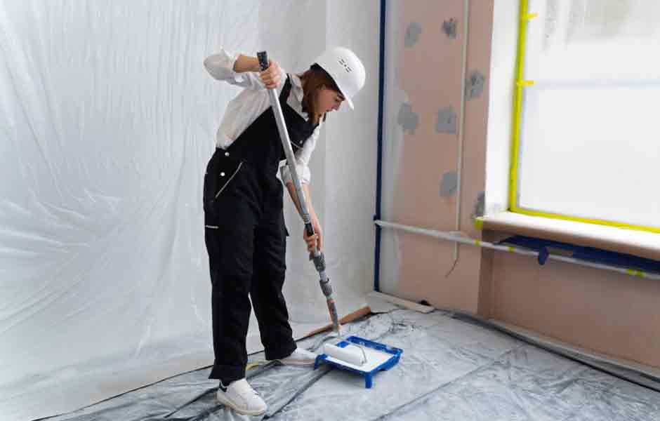 Görselde, kadın boyacı ustası, odanın duvarlarını boyamadan önce, boya sıçramaması için yerlere naylon örtü sermiş ve doğal gaz borularını kağıt bantla kaplamış. Bu önlemler, boyacının dikkatli ve titiz çalıştığını gösteriyor.